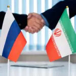 Рукопожатие на фоне флагов России и Ирана — символическая встреча на переговорах в Тегеране