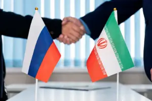Рукопожатие на фоне флагов России и Ирана — символическая встреча на переговорах в Тегеране